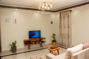 a living room with a couch and a tv on a wall at BRB Homes - Spacious 1 Bedroom Apatment - Bukoto, Kampala in Kampala