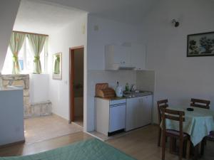 a kitchen and dining room with a table and a table and chairs at Apartments Acalinović in Vis