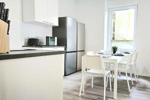 a kitchen with a white table and chairs in a room at Apartments in Altena in Altena