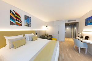 a bedroom with a large white bed and a desk at Crowne Plaza - Marseille Le Dôme in Marseille