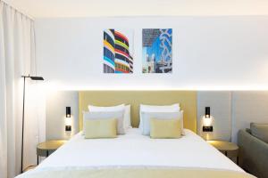 a bedroom with a large white bed with yellow pillows at Crowne Plaza - Marseille Le Dôme in Marseille