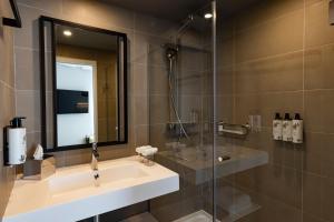 a bathroom with a sink and a glass shower at Crowne Plaza - Marseille Le Dôme in Marseille