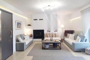 ein Wohnzimmer mit 2 Sofas und einem Tisch in der Unterkunft Varkiza Sea View Apartment - Free Parking in Vari