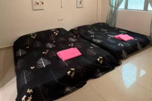 uma cama preta com toalhas cor-de-rosa em cima em D'Sea Marina Island Resort by Manhattan Group em Lumut
