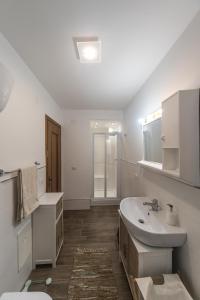 a white bathroom with a sink and a toilet at Villa Gabriella con vista mare, internet e parcheggio in Pisciotta