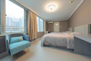 a bedroom with a bed and a blue chair at 皇后超級管家 in Hong Kong