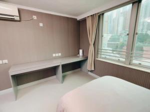 a bedroom with a bench and a large window at 皇后超級管家 in Hong Kong