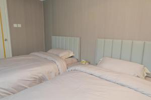 two beds sitting next to each other in a room at 皇后超級管家 in Hong Kong