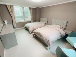 a bedroom with two beds and a window at 皇后超級管家 in Hong Kong
