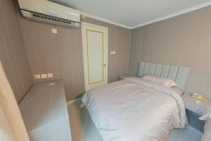 a bedroom with a white bed and a air conditioner at 皇后超級管家 in Hong Kong