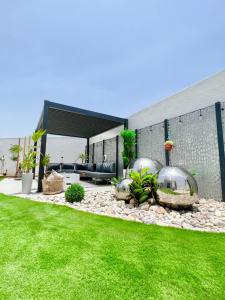 a backyard with a patio with a grass yard at Rosella Chalet in Qurayyah