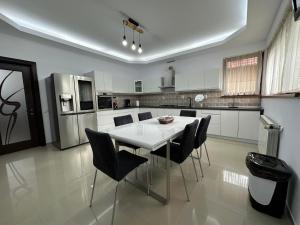 a kitchen with a white table and black chairs at Casa Diecilor in Vatra Dornei +7 photos