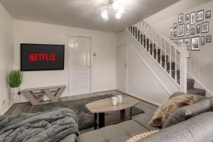 uma sala de estar com um sofá e uma televisão em Cosy Three bedroom house in Radcliffe em Radcliffe