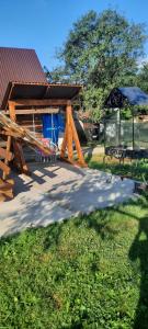 un refugio de picnic con una mesa y una sombrilla en Petite Chambre, en Velyatyn