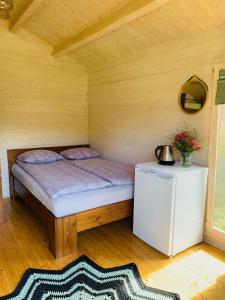 una camera da letto con un letto in una stanza di legno di Orupõhja kämpingud ja telkimisala a Põlva