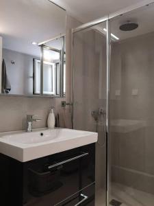 a bathroom with a sink and a shower at Varkiza Sea View Apartment - Free Parking in Vari