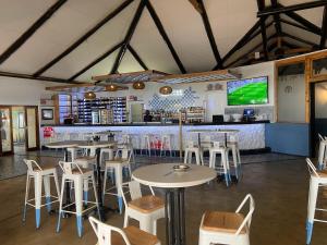 een restaurant met tafels en stoelen en een bar bij Teak Place Guest Rooms in Krugersdorp