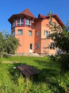 a large house in a grassy yard with a table in front at Domashnya Oselya in Verkhovyna