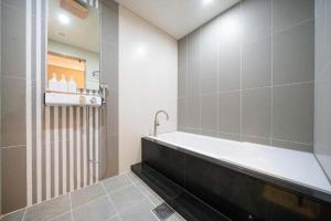 Naju的住宿－Hotel Core，设有带浴缸和淋浴的浴室。