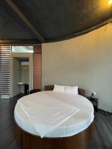 a bedroom with a large bed with white sheets at Homestay Bảo Lộc in Bao Loc