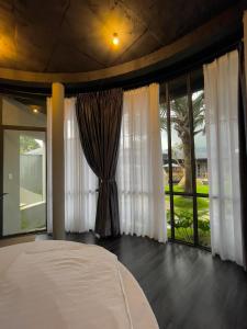 um quarto com uma cama grande e janelas grandes em Homestay Bảo Lộc em Bao Loc
