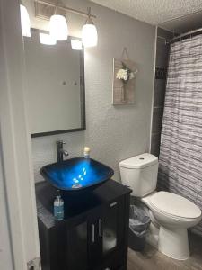 y baño con lavabo azul y aseo. en Walk to AT&T Stadium! Free parking on Premises en Arlington