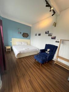 1 dormitorio con 1 cama y 1 silla azul en Catcat Garden House, en Sa Pa