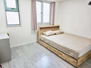 sypialnia z łóżkiem i 2 oknami w obiekcie BoA Travel House w Seulu