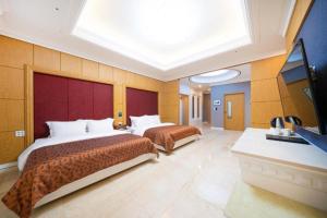 2 bedden in een hotelkamer met een dakraam bij Hotel Core in Naju