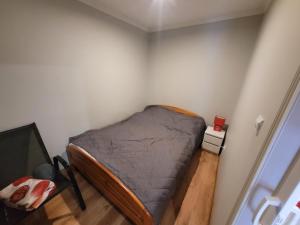 niewielka sypialnia z łóżkiem w rogu w obiekcie Domek Drewniany w Dolinie Symsarny w Lidzbarku Warmińskim