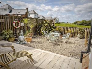 a patio with a table and chairs and a fence at Mariners Moon in Camber