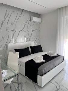 a white bedroom with a bed and a glass table at White Elegance Luxury B&B Caserta in Caserta