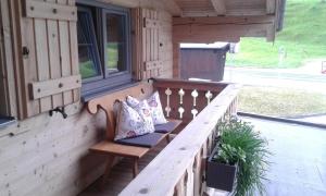 un banc sur la terrasse couverte d'une cabine dans l'établissement Appartement Haus Pichler, à Leogang