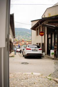 ein weißes Auto, das am Straßenrand geparkt ist in der Unterkunft Hostel Kovači in Sarajevo