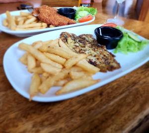 a plate of food with french fries and meat at Daintree Siesta in Diwan