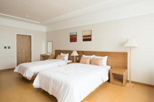 a hotel room with two beds with white sheets at Lake 45 Hotel in Naju