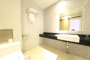 a bathroom with a sink and a mirror and a toilet at Lake 45 Hotel in Naju