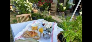 a picnic table with a basket of bread and orange juice at Une envie de montagne in Guillestre