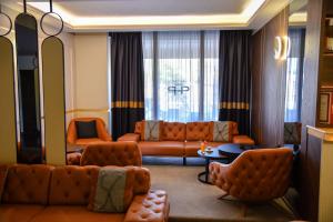 Park Hotel Plovdiv في بلوفديف: غرفة معيشة مع أريكة وكراسي في غرفة