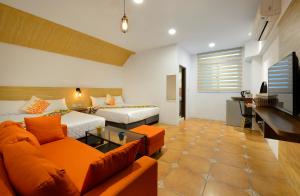 uma sala de estar com duas camas e um sofá em 康逸旅宿Comeinn2 em Hengchun South Gate