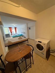 Habitación con cama, mesa y lavadora. en Eco urban apartemt en Atenas