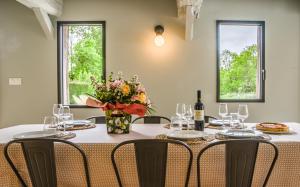 a table with chairs and a vase of flowers on it at Authentique et charmante longère bord de mer in Sainte-Marguerite