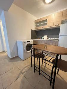 a kitchen with a table and a washing machine at Eco urban apartemt in Athens