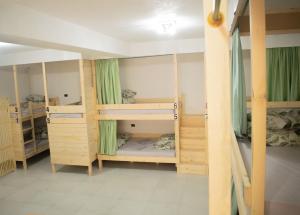 a room with three bunk beds with green curtains at Hostel Kovači in Sarajevo