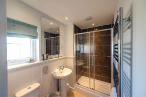 a bathroom with a sink and a shower and a toilet at Camber Cottage in Camber +44 photos