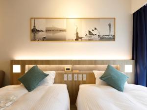 福岡市にあるプレジデントホテル博多のベッド2台が備わる客室で、壁に絵が描かれています。
