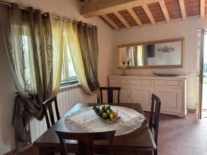 una mesa de comedor con un bol de fruta. en Villa i tre Cipressi, en Agnano