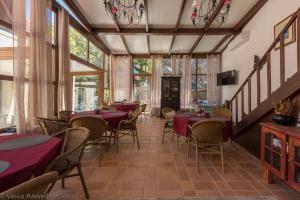 a restaurant with red tables and chairs and windows at Guest House Villa dos Poetas in Sintra