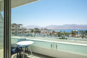 a view from the balcony of a hotel with a table and chairs at Beach side -Luxury sea View Amazing pool Eilat in Eilat