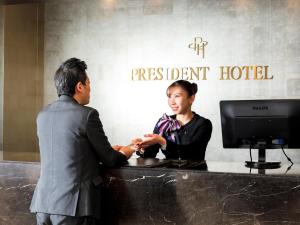 Un homme et une femme serrent la main sur un bureau dans l'établissement President Hotel Hakata, à Fukuoka